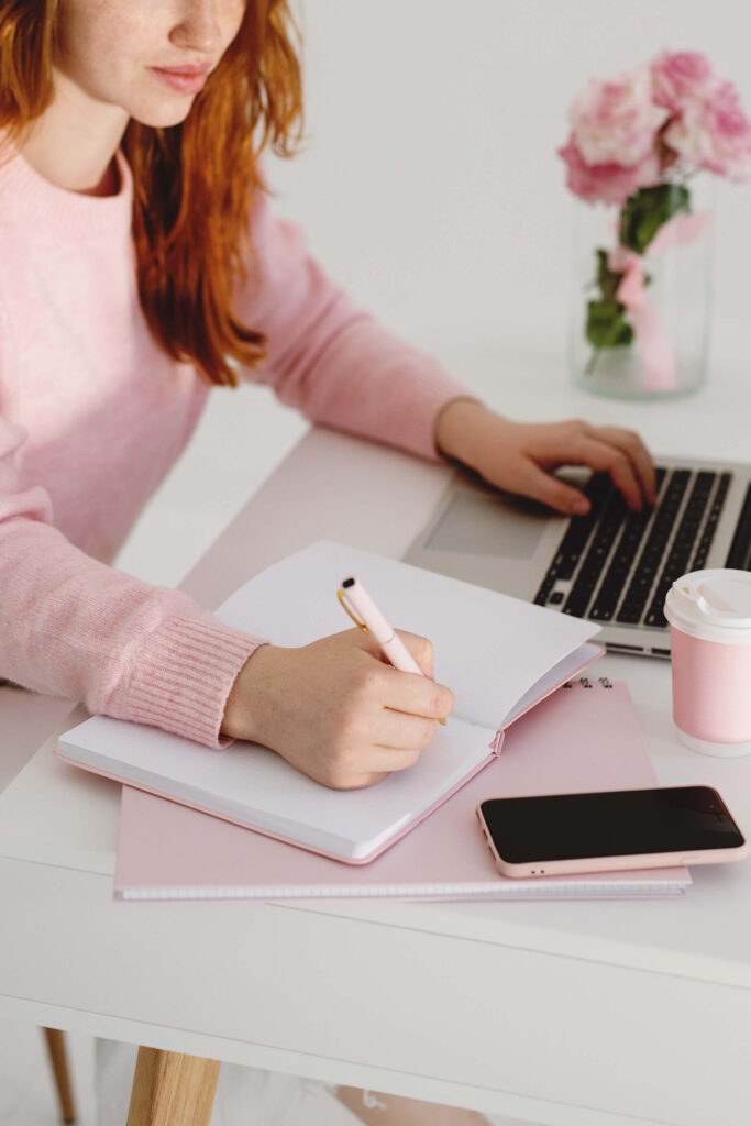 Woman at desk and writing in notebook